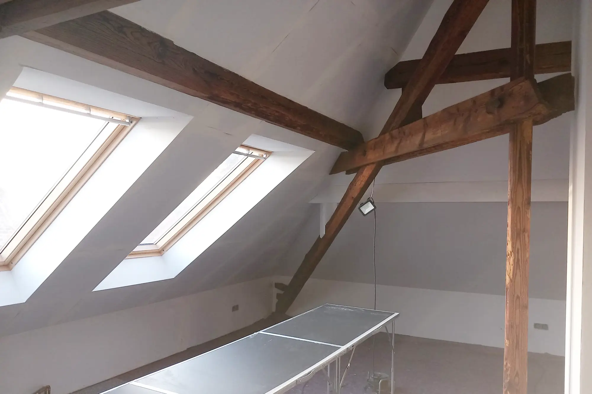 Dachgeschosszimmer mit Balken und Dachfenstern